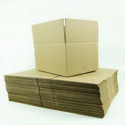 Cajas de cartón planas y apiladas, listas para armar, junto a una caja armada