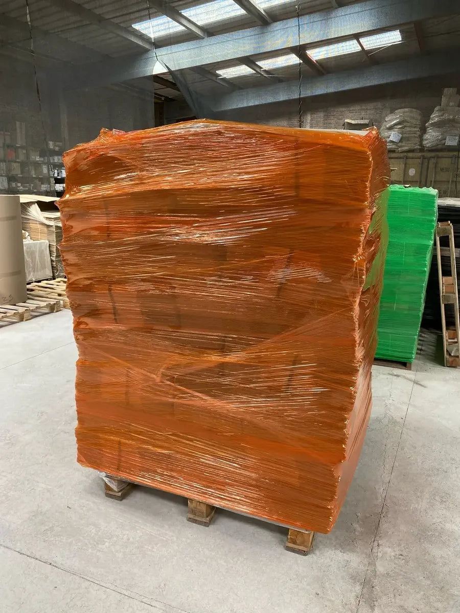 Pallet envuelto con film stretch naranjo en bodega Japipack